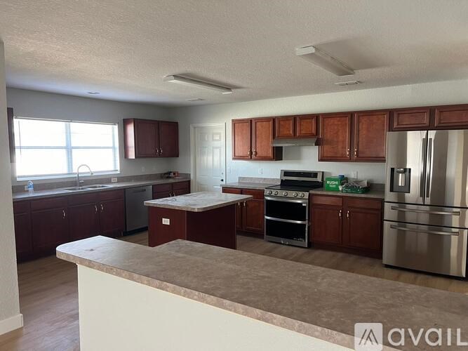 A kitchen with brown cabinets and a white island.