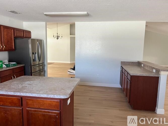 A kitchen with dark wood cabinets and a marble countertop.