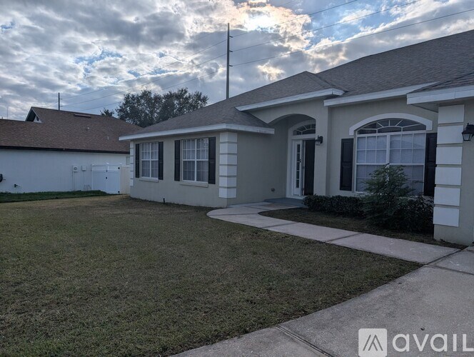 A house with a grey roof and a white garage door is available for rent.