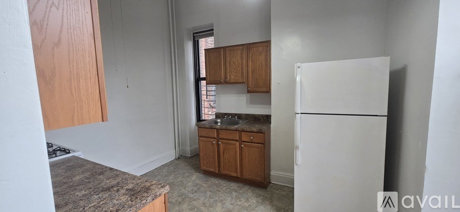 A kitchen with a white fridge and wooden cabinets.