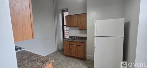 A kitchen with a white fridge and wooden cabinets.
