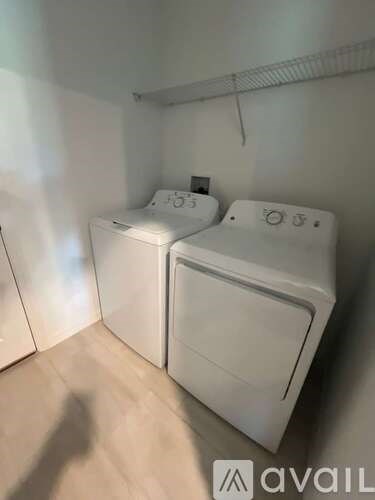 Two white front loading washing machines in a laundry room.