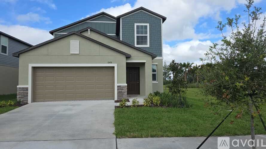 A two-story house with a garage is available for sale.