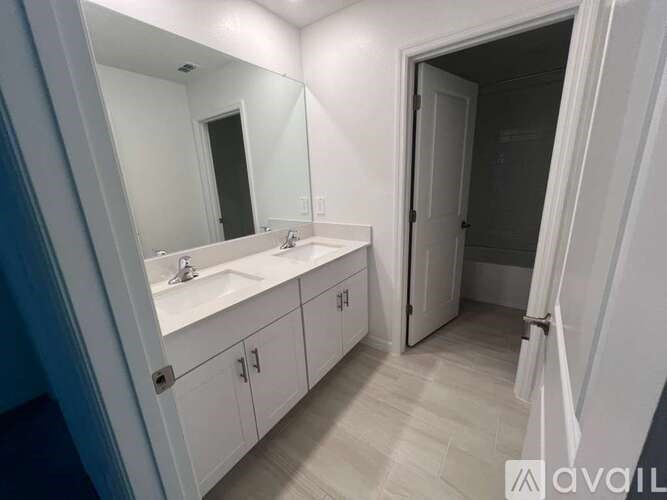 A bathroom with a sink, mirror, and cabinets.