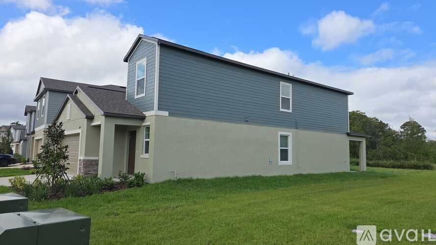 A house with a grey roof and a green lawn in front.