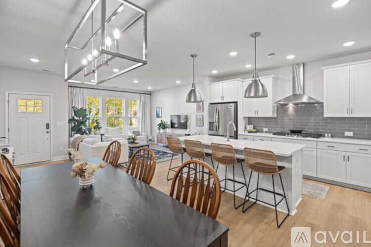 A modern kitchen with a black table and wooden chairs.