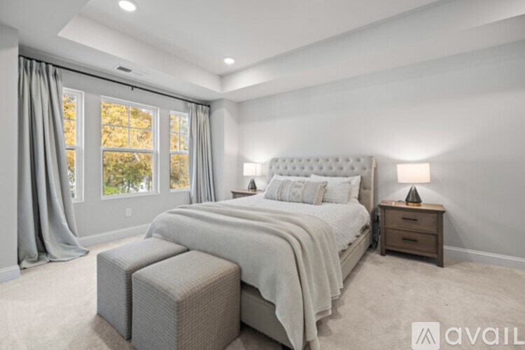 A bedroom with a large bed and a window with curtains.