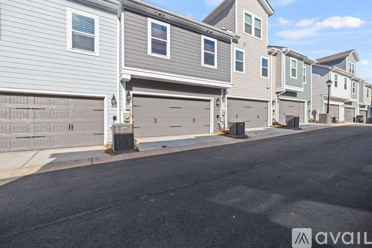A row of houses with garages on the side.