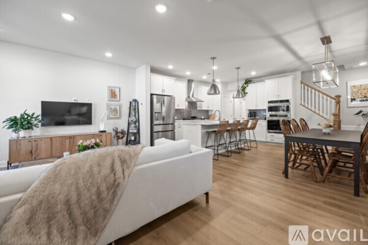 A modern living room with a white couch and a wooden dining table.