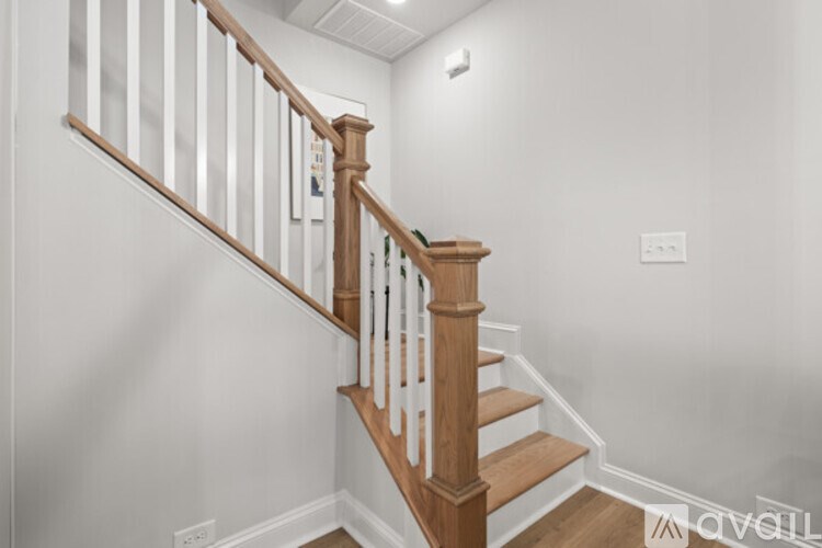 A wooden staircase with white railings.