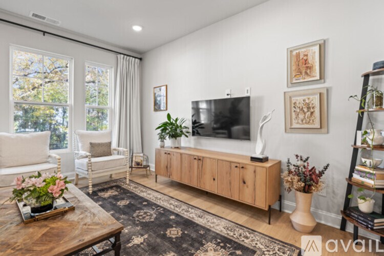 A living room with a wooden coffee table and a flat screen TV mounted on the wall.