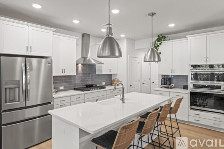 A modern kitchen with stainless steel appliances and white countertops.