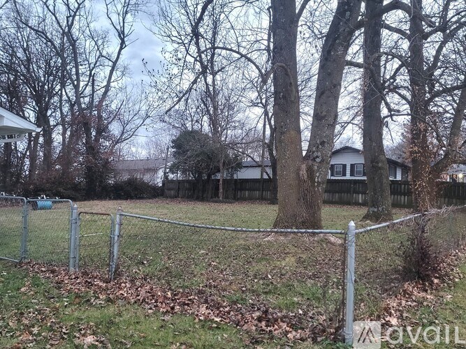 A fenced yard with a house in the background.