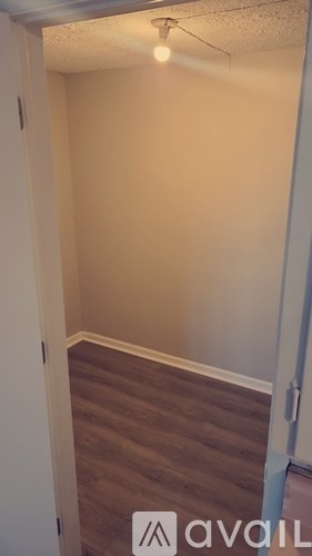 A room with a wooden floor and a white wall.