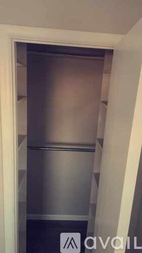 A stainless steel refrigerator is installed in a narrow space.