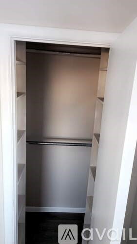 A stainless steel refrigerator is built into a wall.