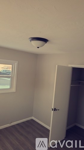 A room with a white door and a window.