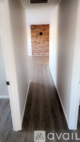 A long hallway with a brick wall at the end.