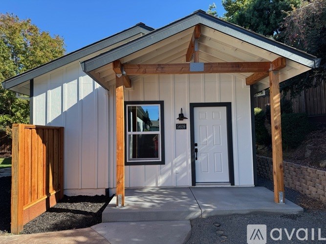 A small white house with a brown door and windows.