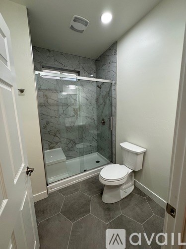 A bathroom with a toilet, sink, and walk-in shower.