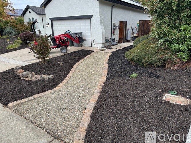 A red lawnmower is parked in a driveway.