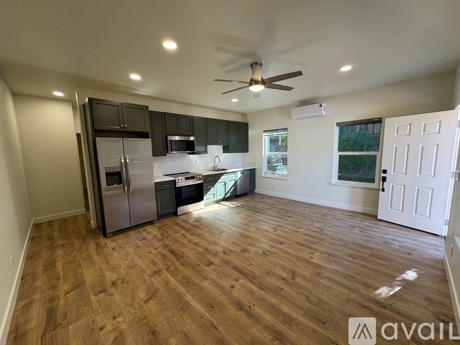 A kitchen with a refrigerator, microwave, and oven.