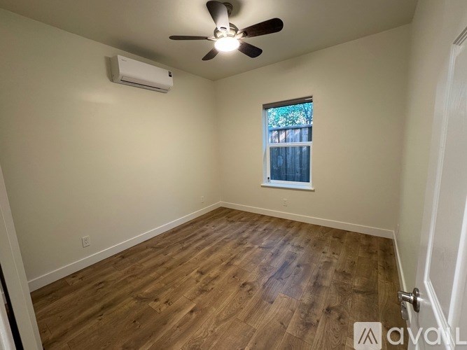 A room with a ceiling fan and wooden flooring.