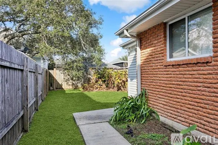 A backyard with a wooden fence and a green lawn.