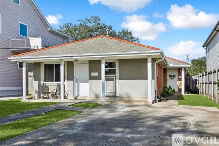 A house with a covered patio and a lawn.