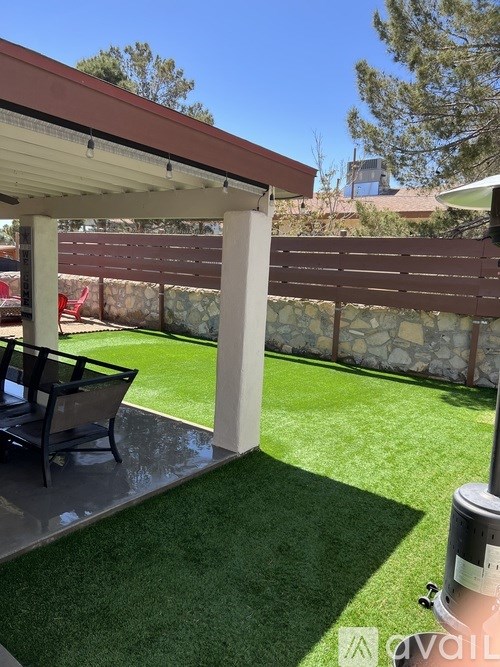 A patio with a table and chairs under a roof.