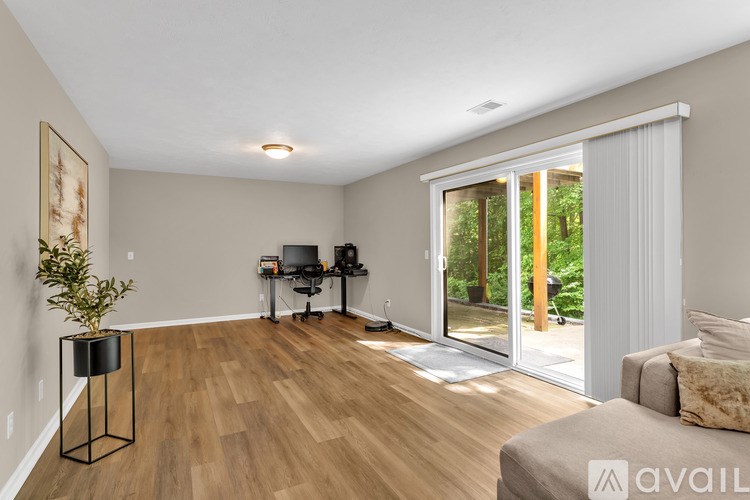 A living room with a couch, a television, and a plant on a stand.