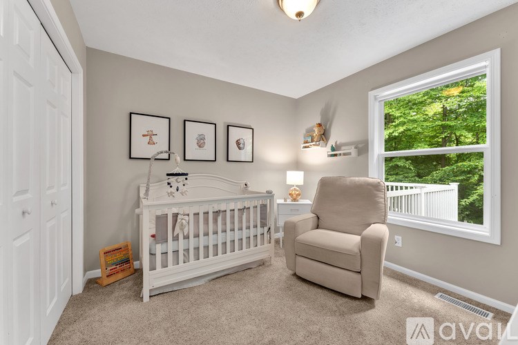 A baby's room with a white crib and a beige chair.