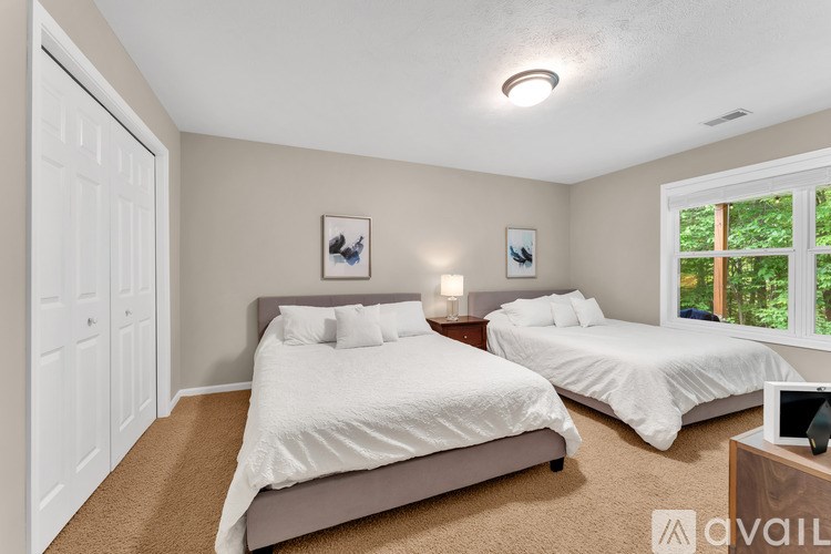 A bedroom with two beds and a window.