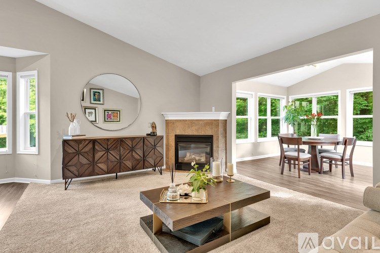 A living room with a fireplace and a dining table.