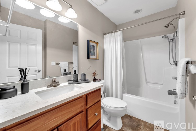 A bathroom with a white tub, sink, and toilet.