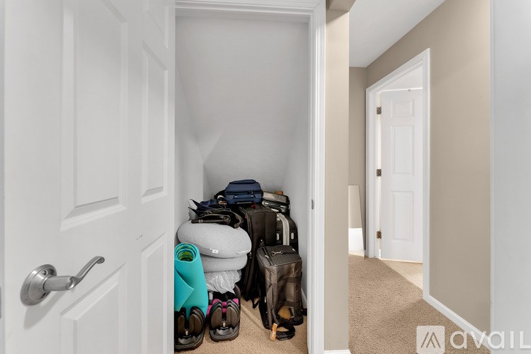 A hallway with a door on the left and a pair of shoes on the floor.
