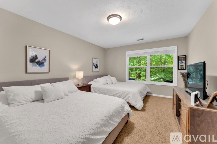 A bedroom with two beds and a television.