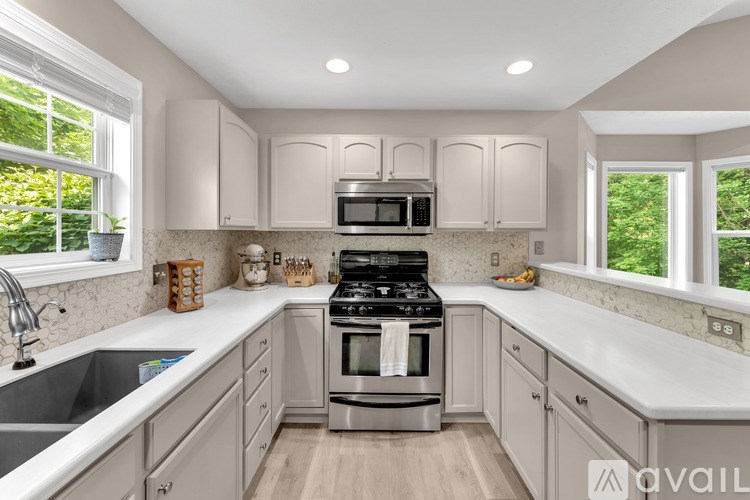 A modern kitchen with a stove top oven and microwave above it.