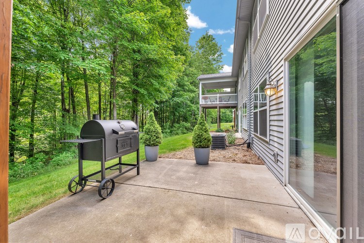 A mailbox is on a cart outside a house.