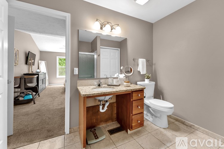 A bathroom with a wooden vanity and a white toilet.