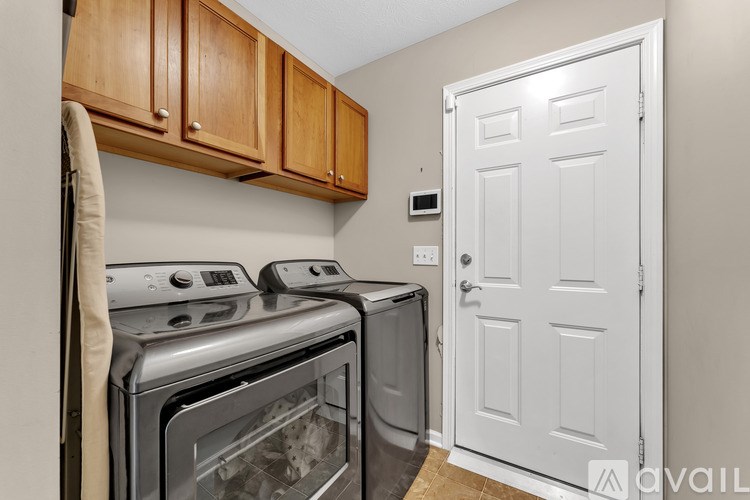 A kitchen with a white door and a stove top oven.