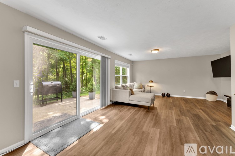 A living room with a white couch and a television on the wall.
