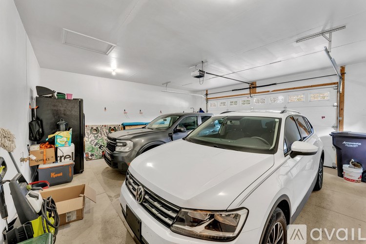 A white Volkswagen car is parked in a garage with other vehicles.