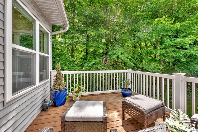 A patio with a table and chairs overlooking a forest.