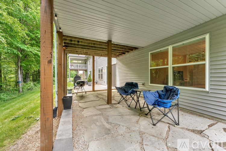 A covered patio with a table and chairs.