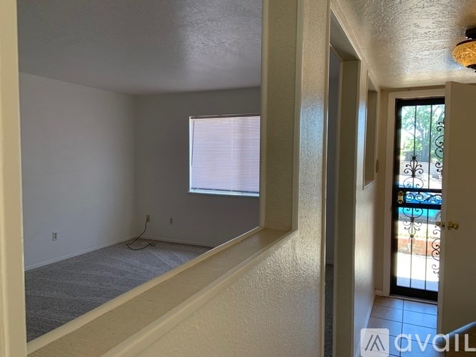 A room with a window and a door leading to a balcony.