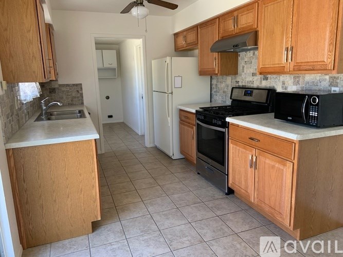A kitchen with wooden cabinets and a black stove top oven.