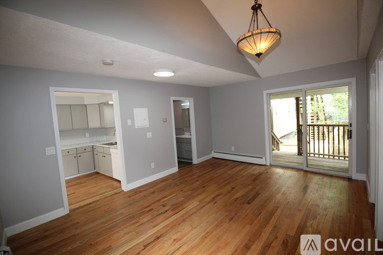 A room with wooden floors and a hanging light fixture.