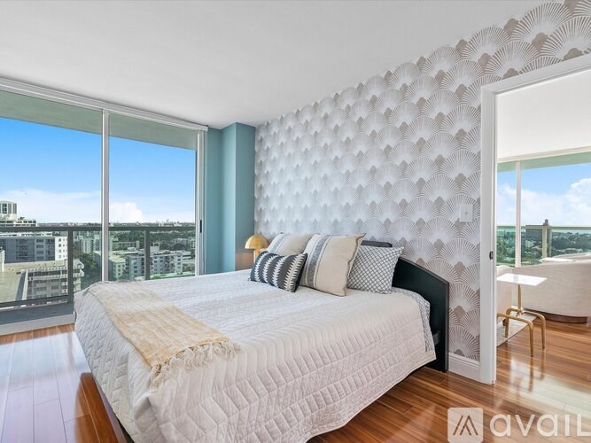 A bedroom with a large bed and a window overlooking a cityscape.