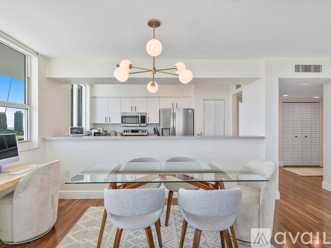 A modern kitchen with a glass table and chairs.